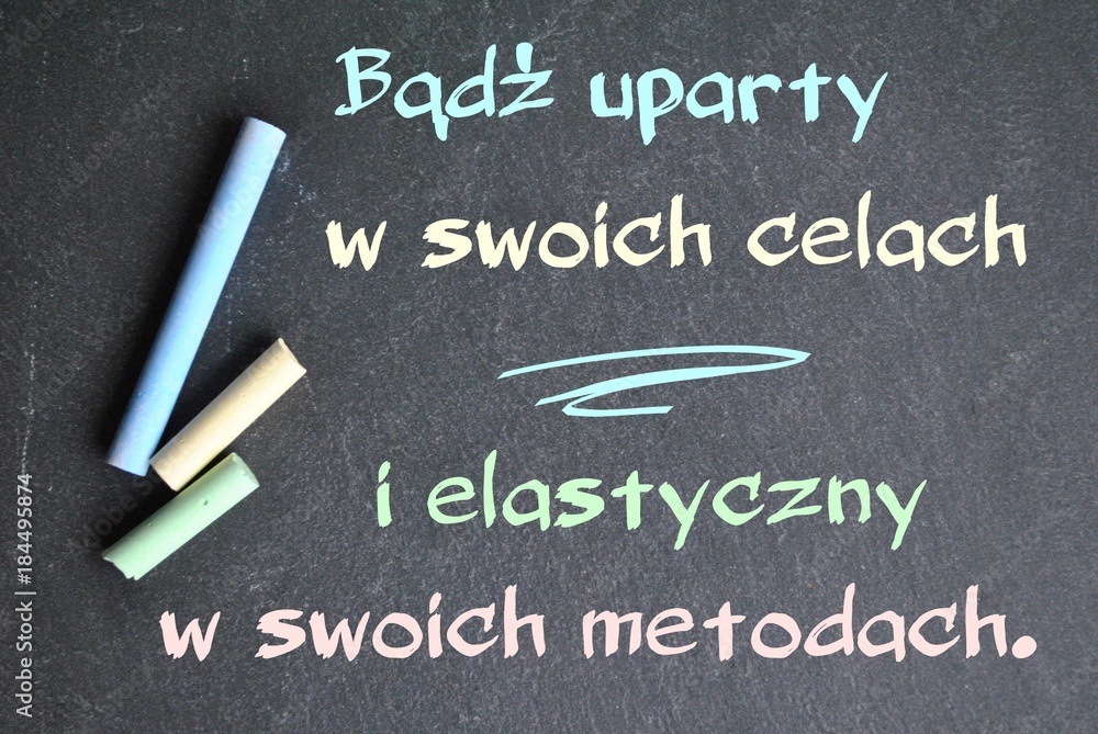 Napis kredą na tablicy 'Bądź uparty w swoich celach i elastyczny w swoich metodach' w pastelowych kolorach symbolizujący równowagę między determinacją a adaptacją