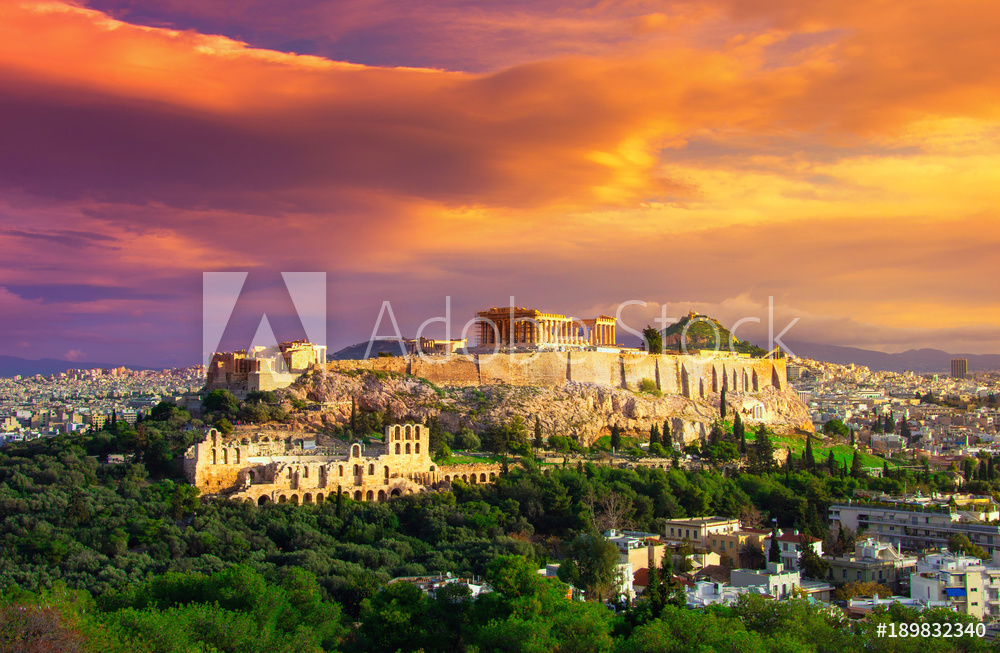 Acropolis with Parthenon. View through a frame with green plants, trees, ancient marbles and cityscape, Athens, Greece.