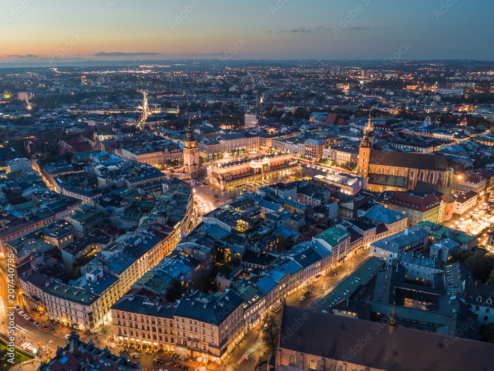 Widok z lotu ptaka na nocny Rynek Główny w Krakowie z oświetloną Bazyliką Mariacką i Sukiennicami - obraz drukowany na płótnie