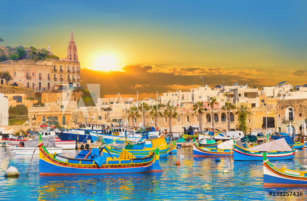 Marsaxlokk village harbor of Malta, illuminate by sunset light