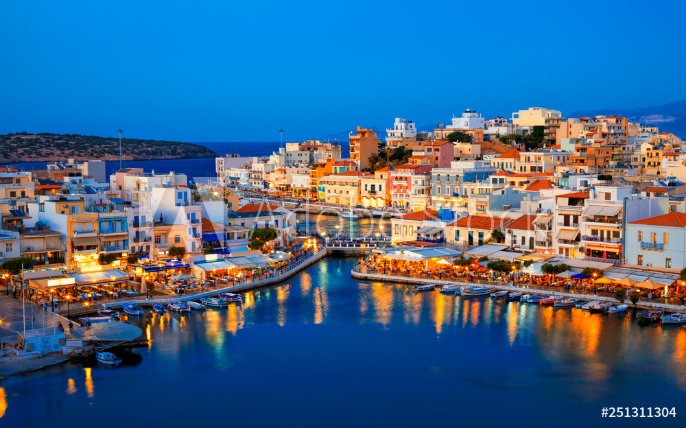 Agios Nikolaos resort town skyline in the evening and Voulismeni lake in Crete island, Greece.