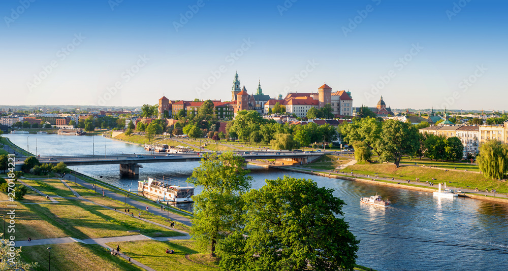Panoramiczna fotografia Krakowa z Wawelem, Wisłą, mostami i zielenią w ciepłym złotym świetle - obraz drukowany na płótnie