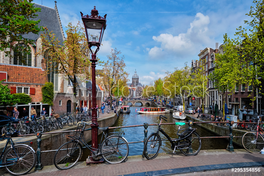 Obraz na płótnie Bicycles in Amsterdam street near canal with old houses w salonie