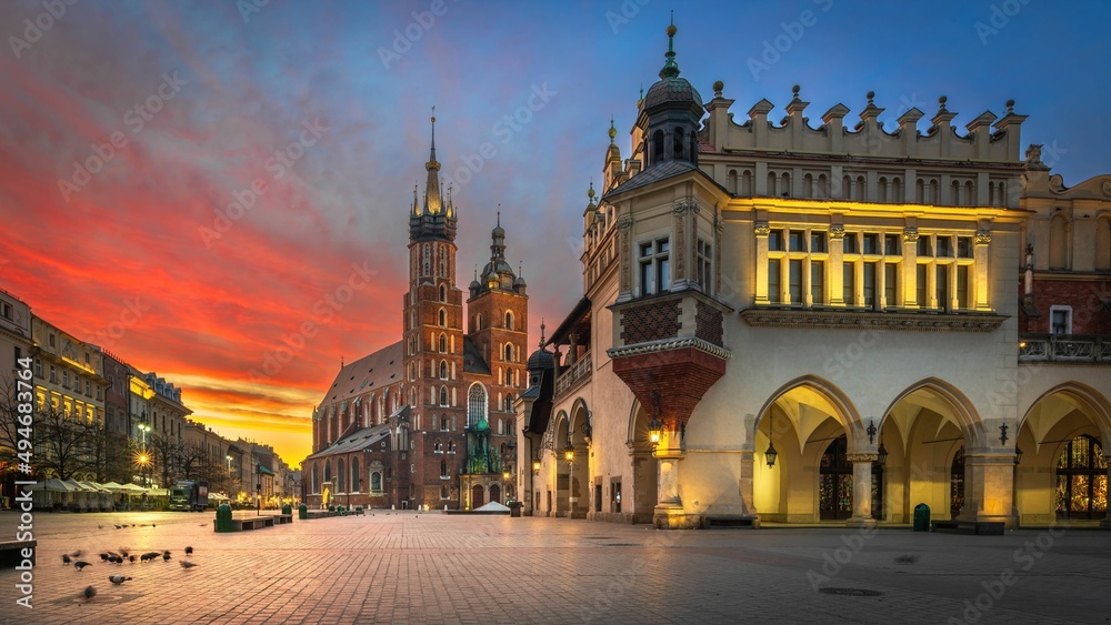 Panorama historycznego Rynku Głównego w Krakowie z Sukiennicami i Bazyliką Mariacką w złotym świetle zachodu na tle granatowego nieba - obraz drukowany na płótnie