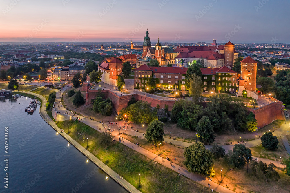 Panorama lotnicza Zamku Królewskiego na Wawelu o zmierzchu z Wisłą i bulwarami w granatowo-złotych tonach - obraz drukowany na płótnie